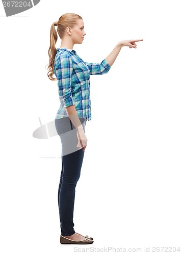 Image of smiling young woman choosing something in the air