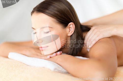 Image of beautiful woman in spa salon getting massage