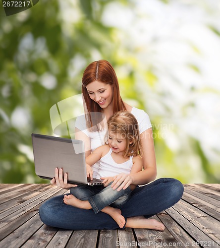 Image of happy mother with adorable little girl and laptop
