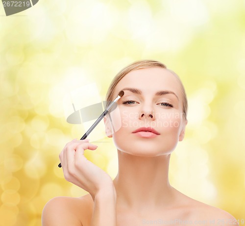 Image of beautiful woman with makeup brush