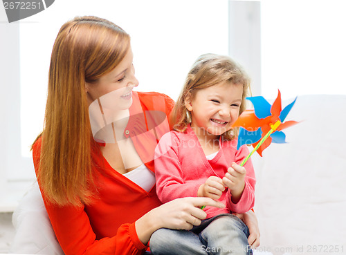 Image of happy mother and daughter with pinwheel toy