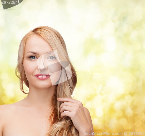 Image of beautiful woman playing with long hair