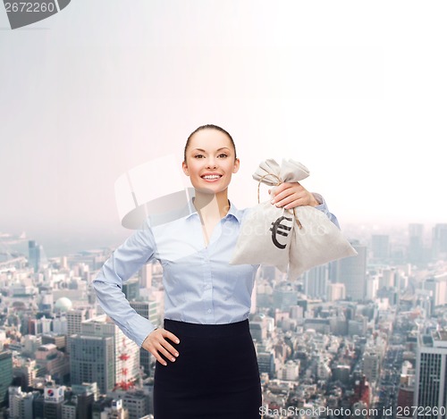 Image of young businesswoman holding money bags with euro