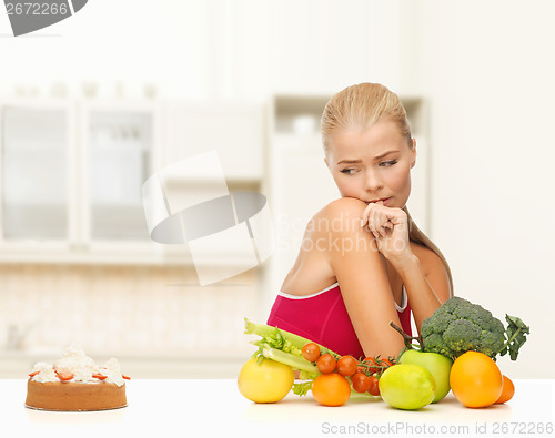 Image of doubting woman with fruits and pie