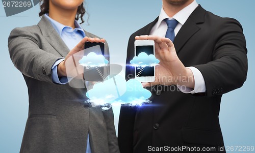 Image of businessman and businesswoman with smartphones