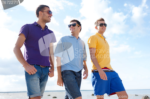 Image of group of male friends walking on the beach