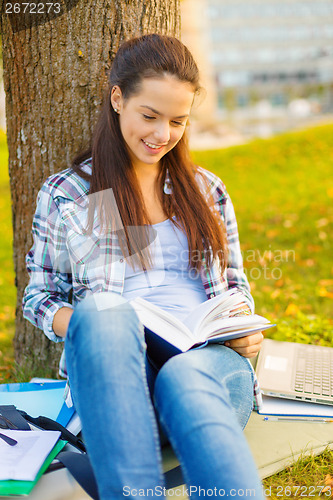 Image of smiling teenager reading book