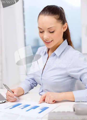 Image of businesswoman with phone, laptop and files