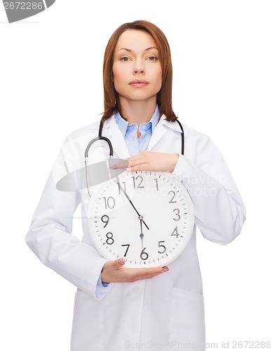 Image of calm female doctor with wall clock