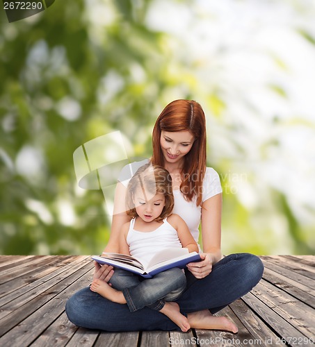 Image of happy mother with adorable little girl and book