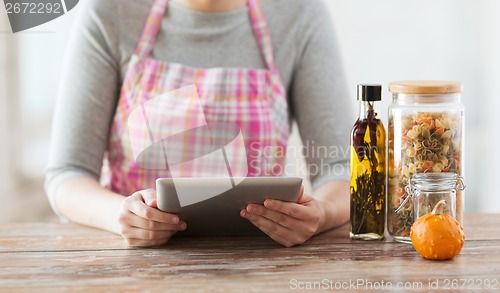 Image of closeup of woman reading recipe from tablet pc