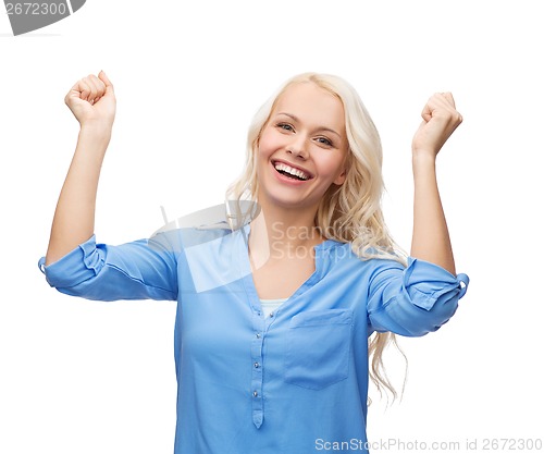 Image of smiling young woman with hands up