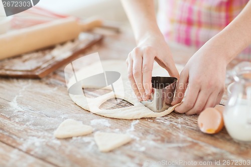 Image of close up of hands making cookies from fresh dough