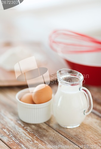 Image of jugful of milk, eggs in a bowl and flour