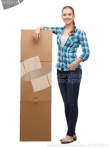 Image of young woman standing next to tower of boxes