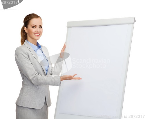 Image of smiling businesswoman standing next to flipboard