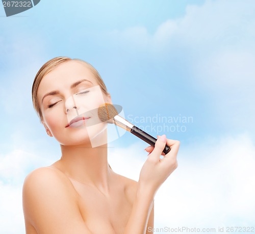 Image of beautiful woman with makeup brush