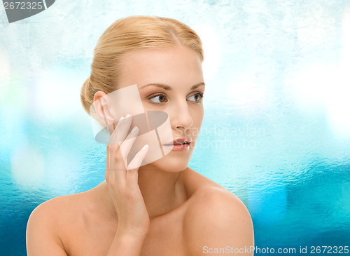 Image of beautiful woman touching her face skin