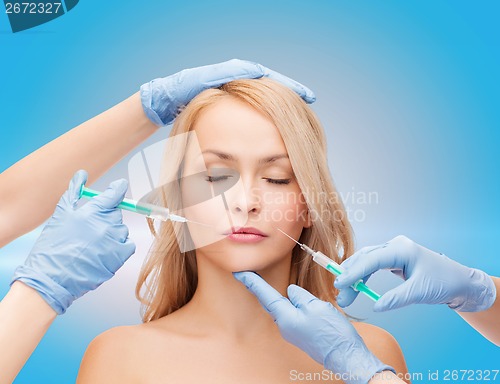 Image of woman face and beautician hands with syringes