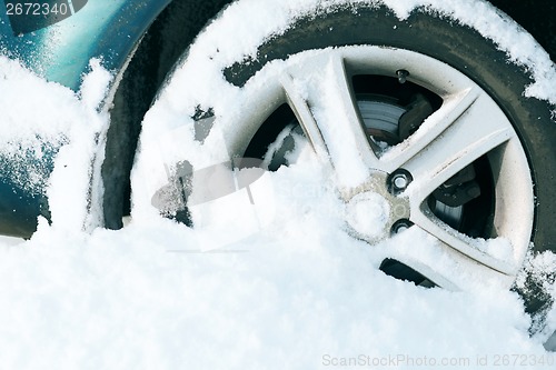 Image of closeup of car wheel stuck in snow