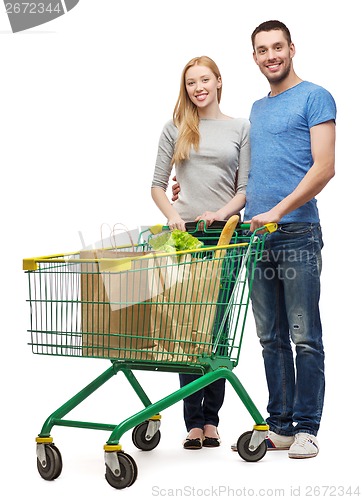 Image of smiling couple with shopping cart and food in it