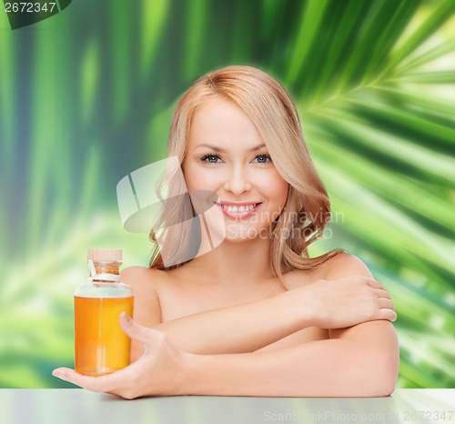 Image of happy woman with oil bottle