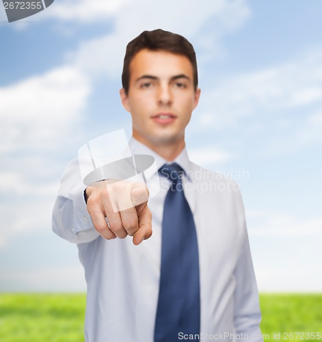 Image of friendly young buisnessman pointing finger