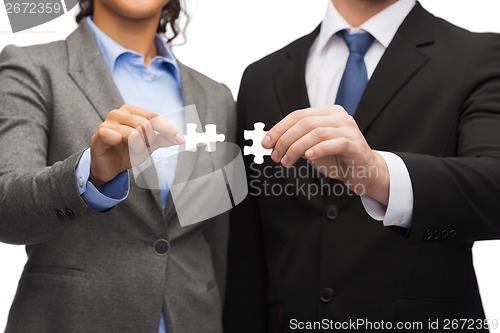 Image of businessman and businesswoman with puzzle pieces