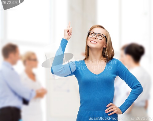 Image of smiling woman pointing her finger up