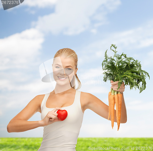 Image of smiling woman holding heart symbol and carrots