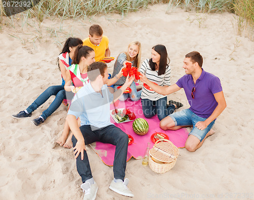 Image of group of friends celebrating birthday on beach