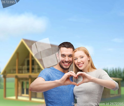 Image of smiling couple showing heart with hands