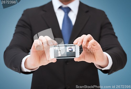 Image of businessman showing smartphone with blank screen