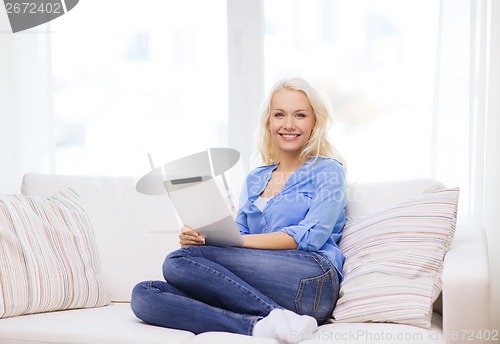 Image of smiling woman with tablet pc computer at home