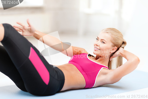 Image of sporty woman doing exercise on the floor
