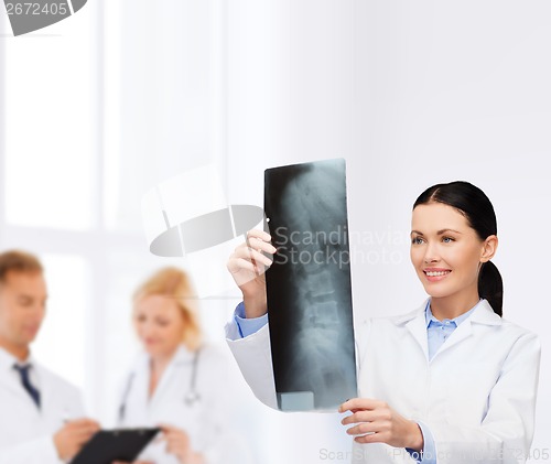 Image of smiling female doctor looking at x-ray