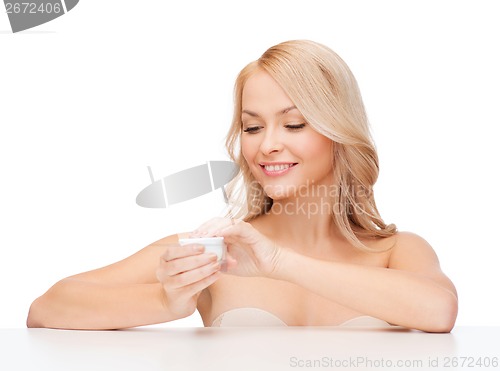 Image of beautiful woman applying cream