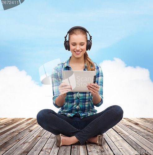 Image of young woman in casual clothes sitting on floor