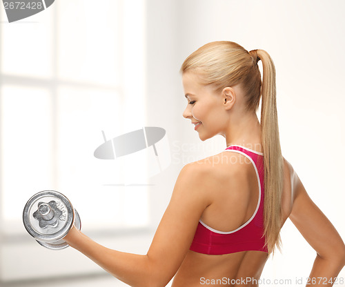 Image of smiling woman with heavy steel dumbbell