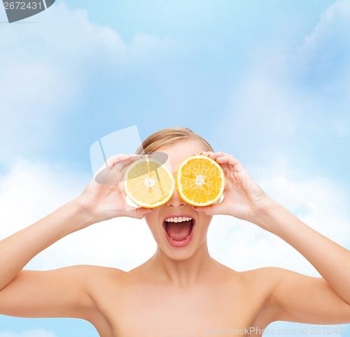 Image of amazed young woman with orange slices