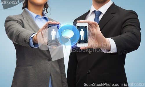 Image of businessman and businesswoman with smartphones