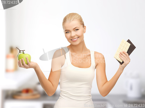 Image of sporty woman with apple and chocolate bars