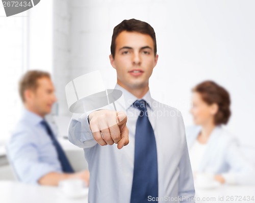 Image of friendly young buisnessman pointing finger