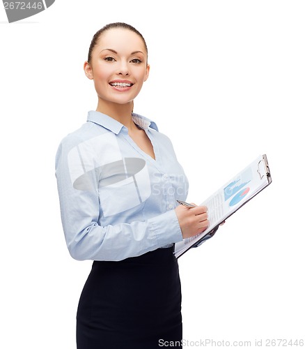 Image of young smiling businesswoman with clipboard and pen