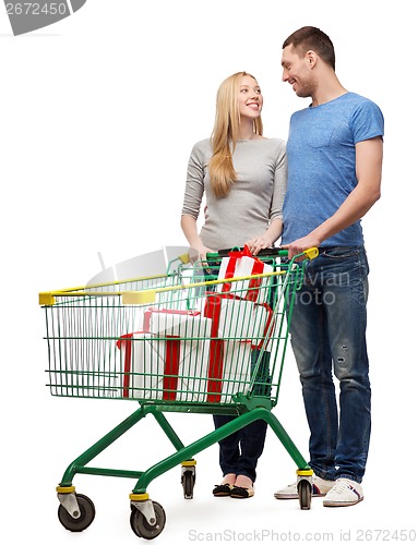 Image of smiling couple with shopping cart and gift boxes