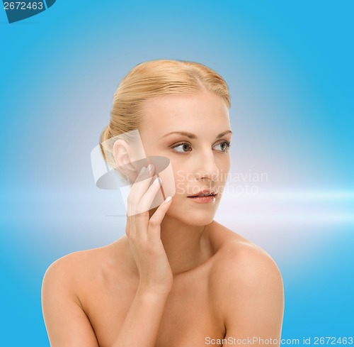 Image of beautiful woman touching her face skin