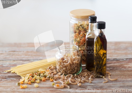 Image of close up of two olive oil bottles and pasta in jar