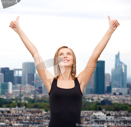 Image of woman in blank black tank top showing thumbs up