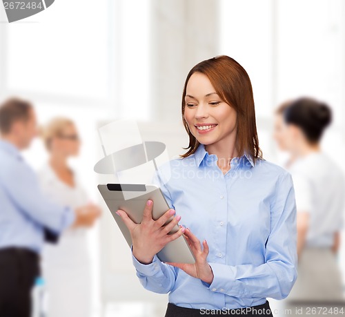 Image of smiling woman looking at tablet pc at office