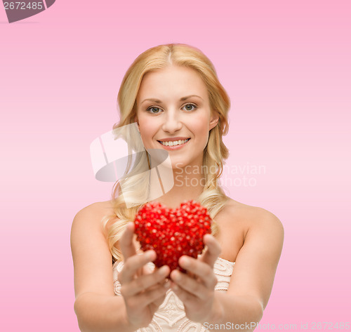 Image of smiling woman giving small red heart